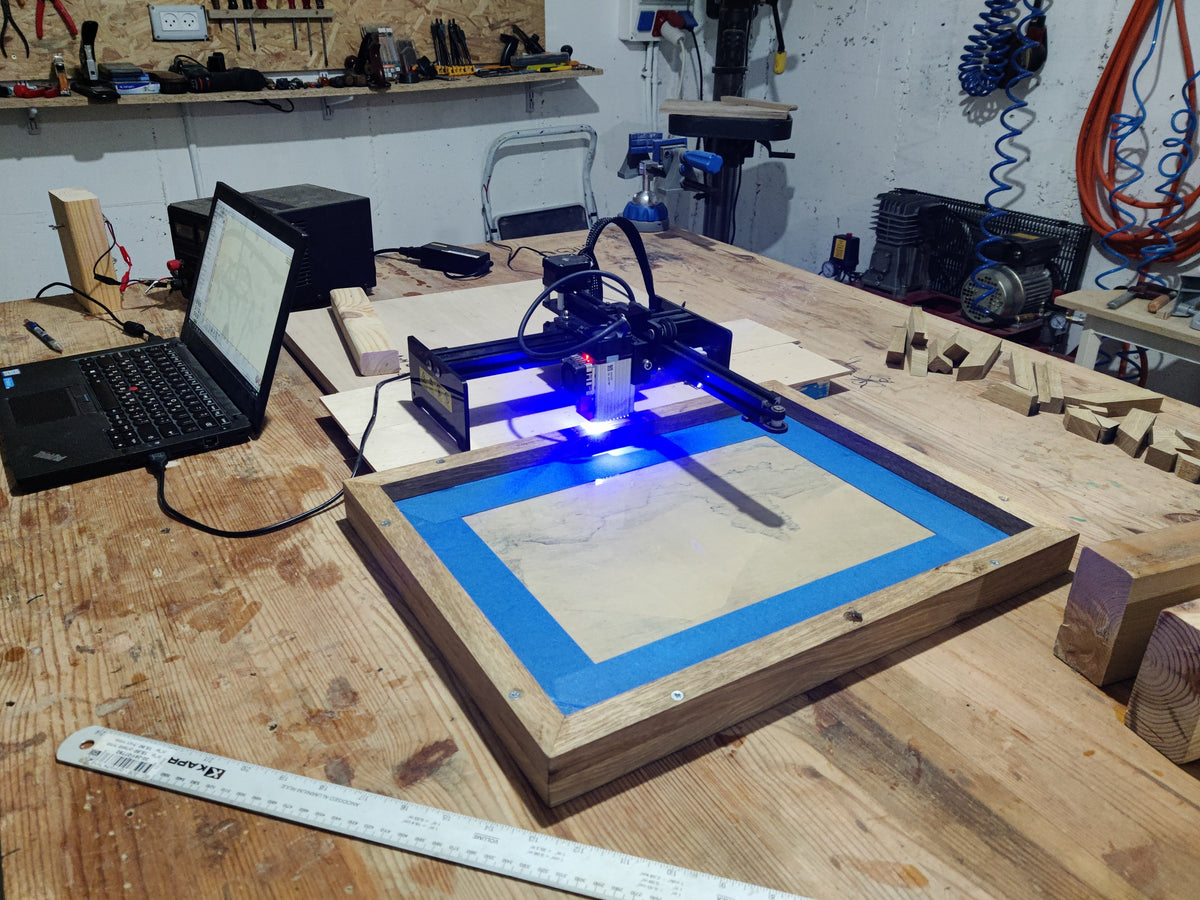 Laser engraving machine on a wooden table in a workshop setting