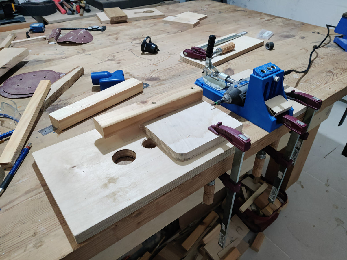 Woodworking setup with a workbench, clamps, and wooden pieces.